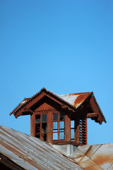 Old wooden attic window on metal roof