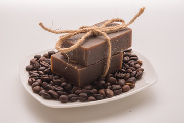 Traditional home made natural coffee soap with a pile of coffee beans on the background suggesting healthy organic non toxic wash products