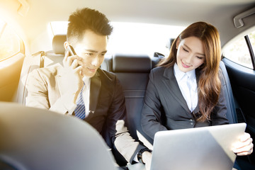 Business man and woman working together in the car