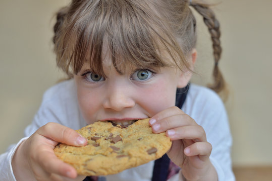 belle enfant mordant dans un cookie