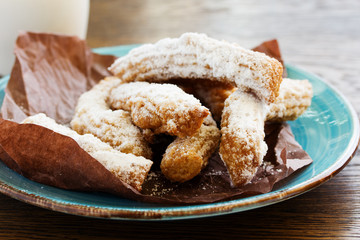 Churros with hot chocolate and powdered sugar.
