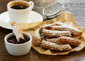 Churros with hot chocolate and powdered sugar.