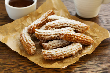 Churros with hot chocolate and powdered sugar.