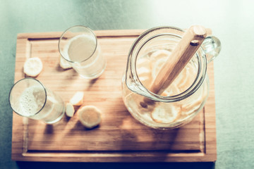 Jug of lemonade on cutting board , top view, toned. Summer drinks with lemon