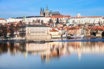 Obraz premium Charles Bridge, St. Vitus Cathedral and other historical buildings in Prague reflected in the river