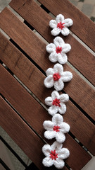 knit daisy flower on wood background