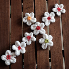 knit daisy flower on wood background