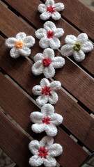 knit daisy flower on wood background