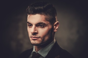 Fototapeta premium Serious well-dressed hispanic man posing on dark background.