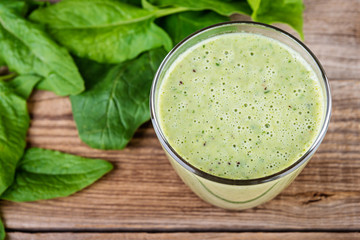 Healthy spinach smoothie on wooden rustic background