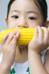 とうもろこしを食べる日本人の女の子