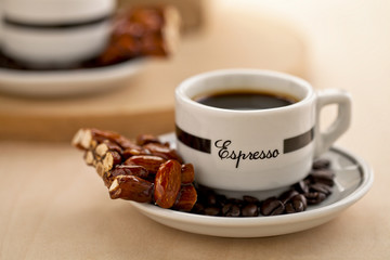 black coffee with coffee beans and almond bar