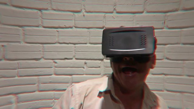 Man wearing virtual reality VR headset glasses fights imaginary creatures during an emotional simulated virtual adventure gaming session - he then encounters a large being.