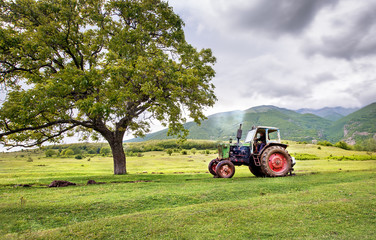Obraz premium Old rusty tractor with storm weather in the background