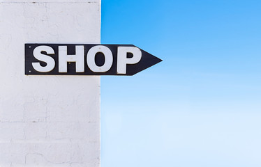 Shop arrow sign Silhouetted Against A Blue Sky