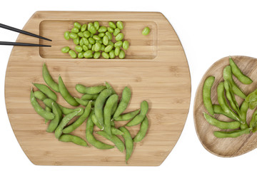 overhead shot of soya beans on wooden plate.