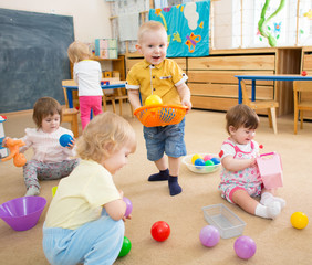 kids playing with balls in kindergarten room 