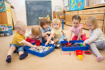 Children improving motor skills of hands with rice and beans 