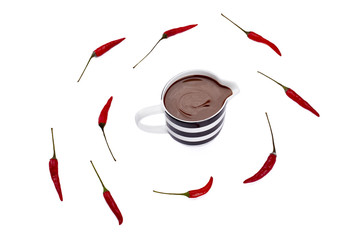 cup of melted chocolate with scattered  red chili
