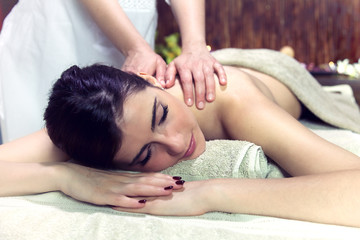 Fototapeta na wymiar Woman getting massage in relaxing spa dreaming