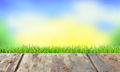 Wooden planks floor in the green grass and blue sky