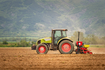 Obraz premium Tractor spraying wheat field with sprayer, herbicides and pestic