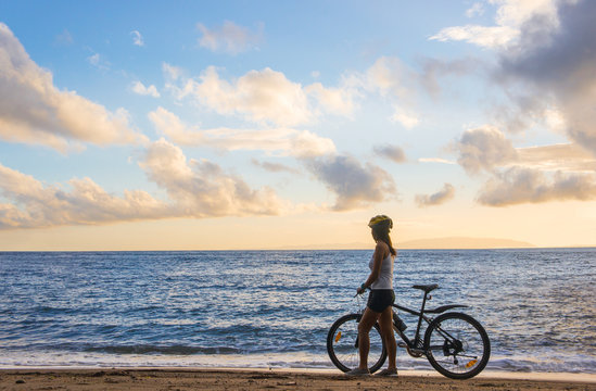 Young woman with bicycle at the beach