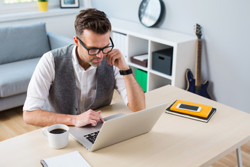 Designer, freelancer working on laptop from home
