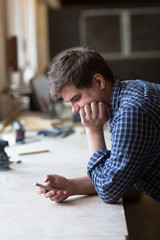 Portrait of senior carpenter working at his workshop while stay