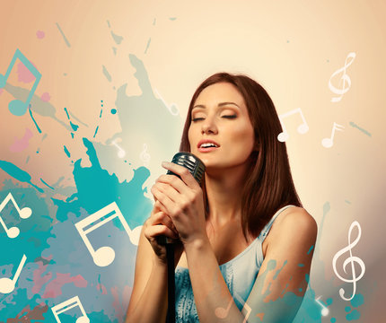 Beautiful woman singing into microphone against color background with notes and clefs