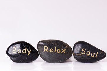 Obraz na płótnie Canvas Stone treatment. Black massaging stones isolated on a white background. Hot stones. Balance. Zen like concepts. Basalt stones.