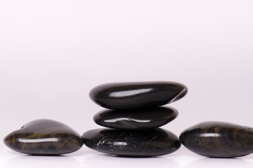 Stone treatment. Black massaging stones isolated on a white background. Hot stones. Balance. Zen like concepts. Basalt stones.