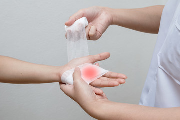 Nurse applying bandage to patient injured hand