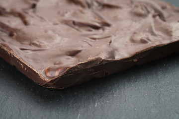 homemade chocolate with almond nuts on slate board, shallow focus