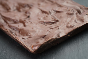 homemade chocolate with almond nuts on slate board, shallow focus