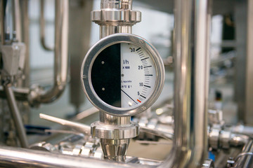 Industrial pressure meter - barometer and water pipes in the background