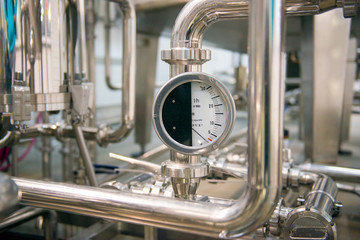 Industrial pressure meter - barometer and water pipes in the background