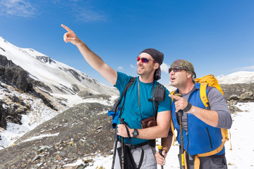 Tourists mountaineers snow mountains pointing finger looking sur