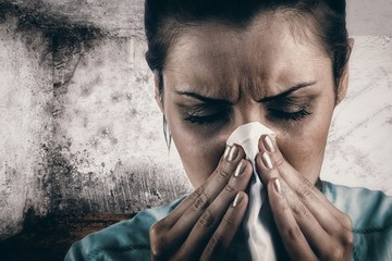 Composite image of portrait of woman blowing her nose - Powered by Adobe