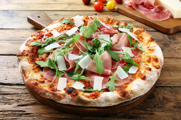 pizza con prosciutto rucola e parmigiano sfondo tavolo legno rustico - 109899048