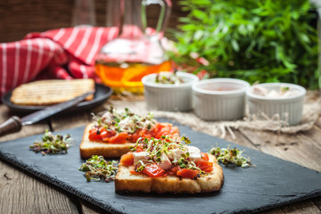 Grilled toasted bread with roasted tomatoes, feta cheese and radish sprouts.