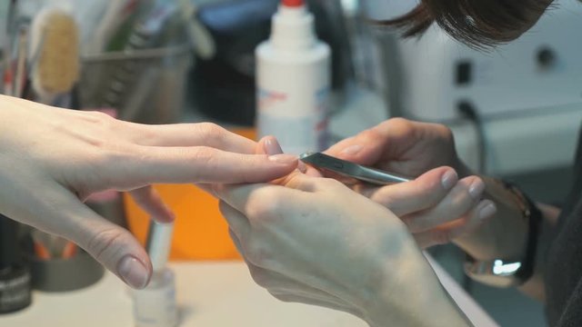 Master makes the girl manicure hands at salon