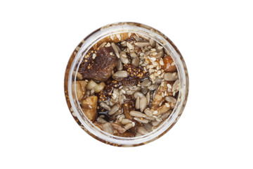 Candied fruits, nuts and organic honey in glass jar. Studio shot, isolated on white.