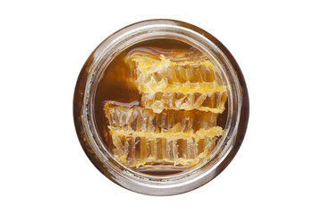 Jar of honey with wooden drizzler on white background