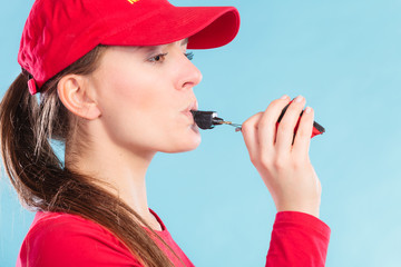 Lifeguard woman blowing whistle.
