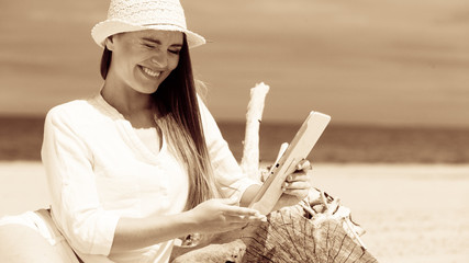 Girl with tablet on seaside.