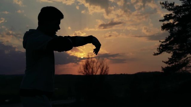 Young man in the art of Wing Chunr on sunset background. 4k