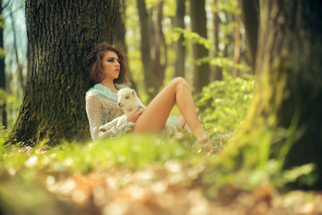 Young woman with goat in forest