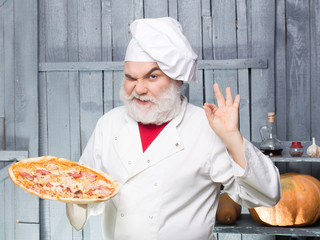 Bearded cook with pizza