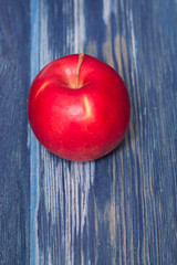 Red apple on blue wood